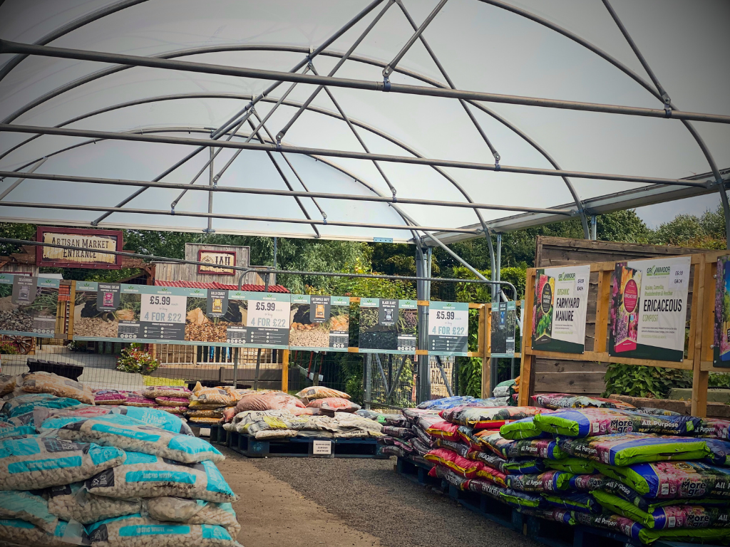A picture of our brand-new compost area at Heaton Fold; featuring a new marquee with pellets of aggregates and composts underneath. 