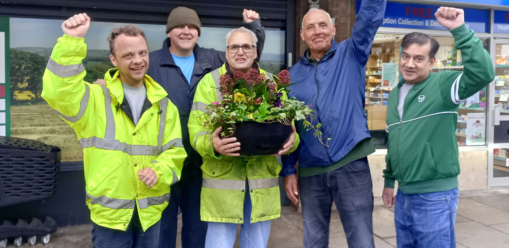 A picture of two students, staff member and members of the Over Hulton Community Group following some community work. 